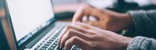 Close up of person typing on a laptop